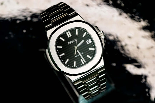Close-up of a Seiko watch with a black dial and stainless steel bracelet, showcasing its unique design and craftsmanship.