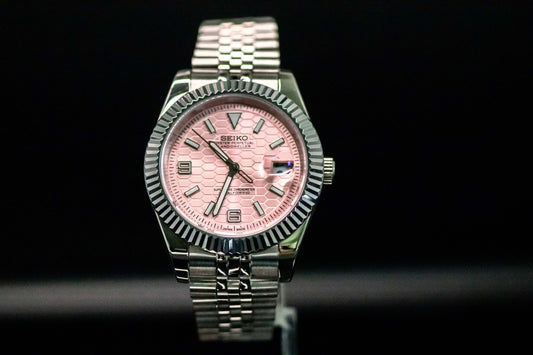 Seiko Mod Pink Land Dweller watch with a salmon dial and stainless steel bracelet, showcasing military-grade toughness.