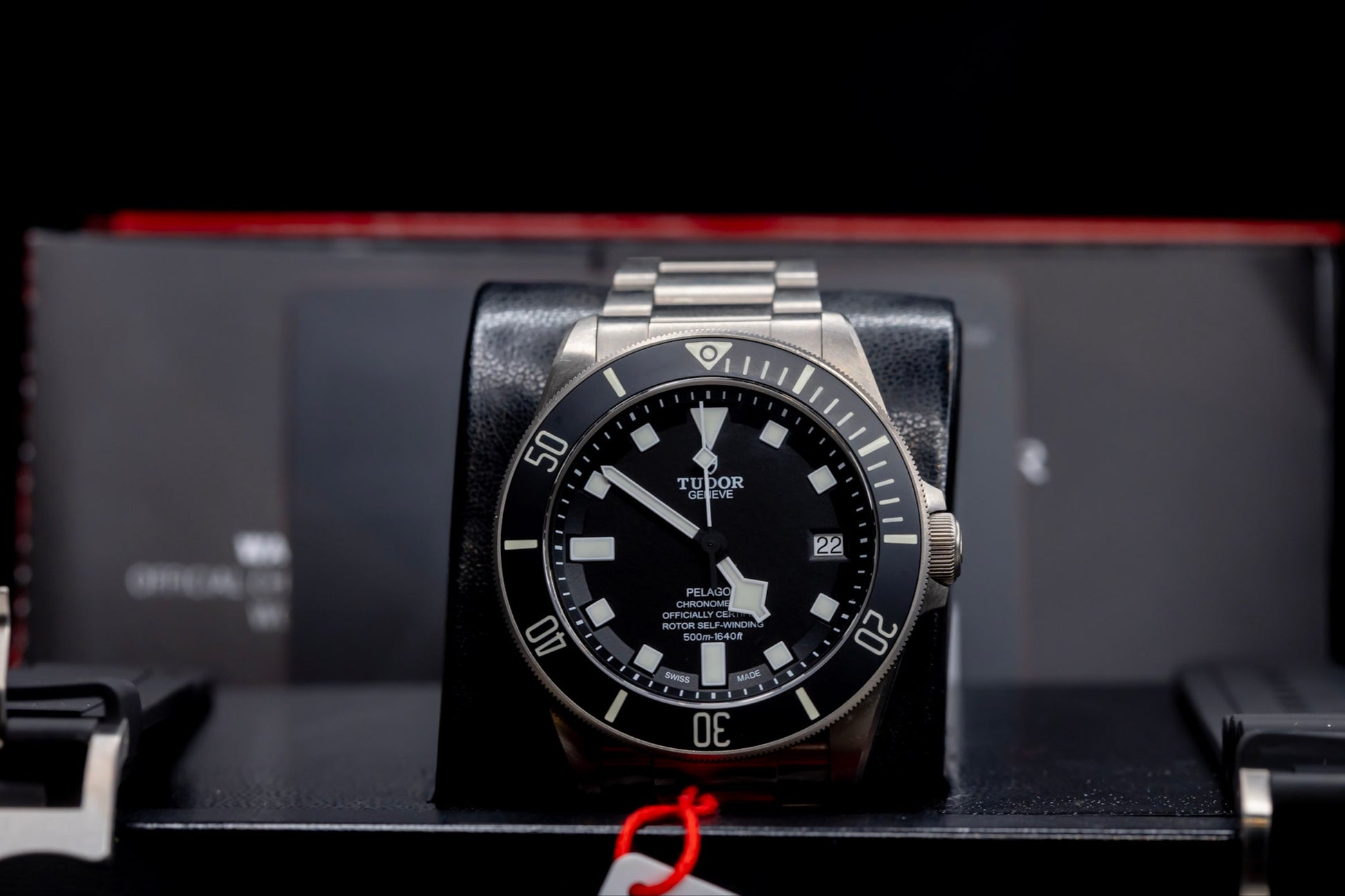 Tudor Pelagos dive watch displayed with a sleek design and titanium casing on a watch stand.