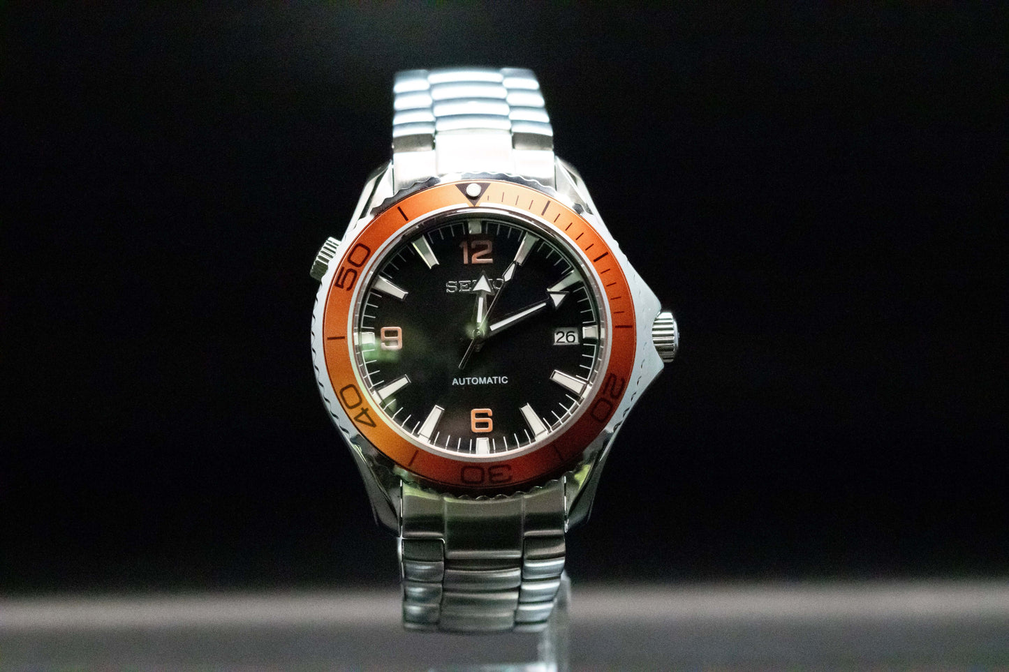 Seikomod Tiger Seamaster Automatic Watch with black dial and orange bezel, set in a polished stainless steel frame.