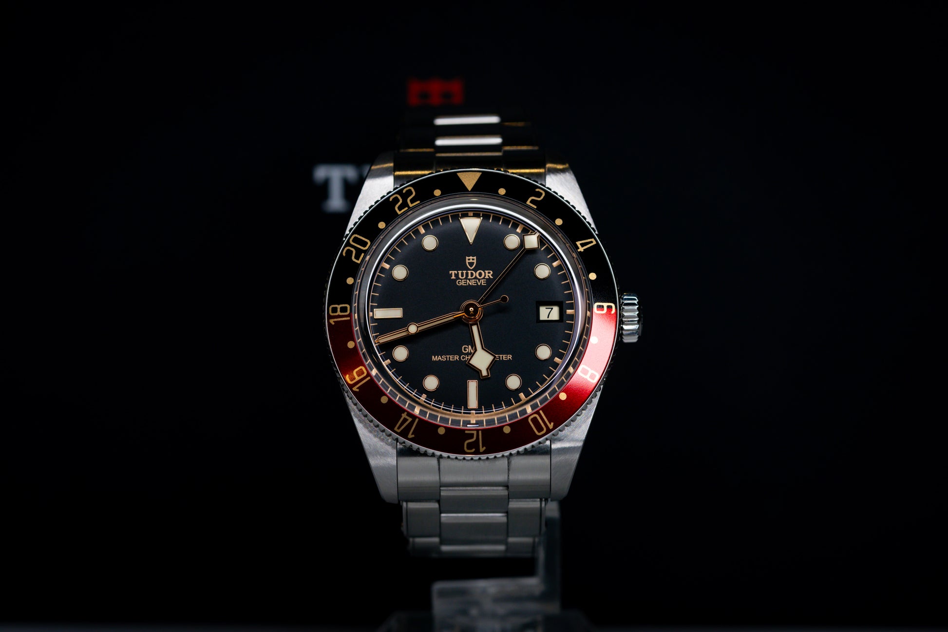 Tudor Black Bay 58 GMT Coke watch with a black dial and silver bracelet, showcasing the automatic movement and GMT features.