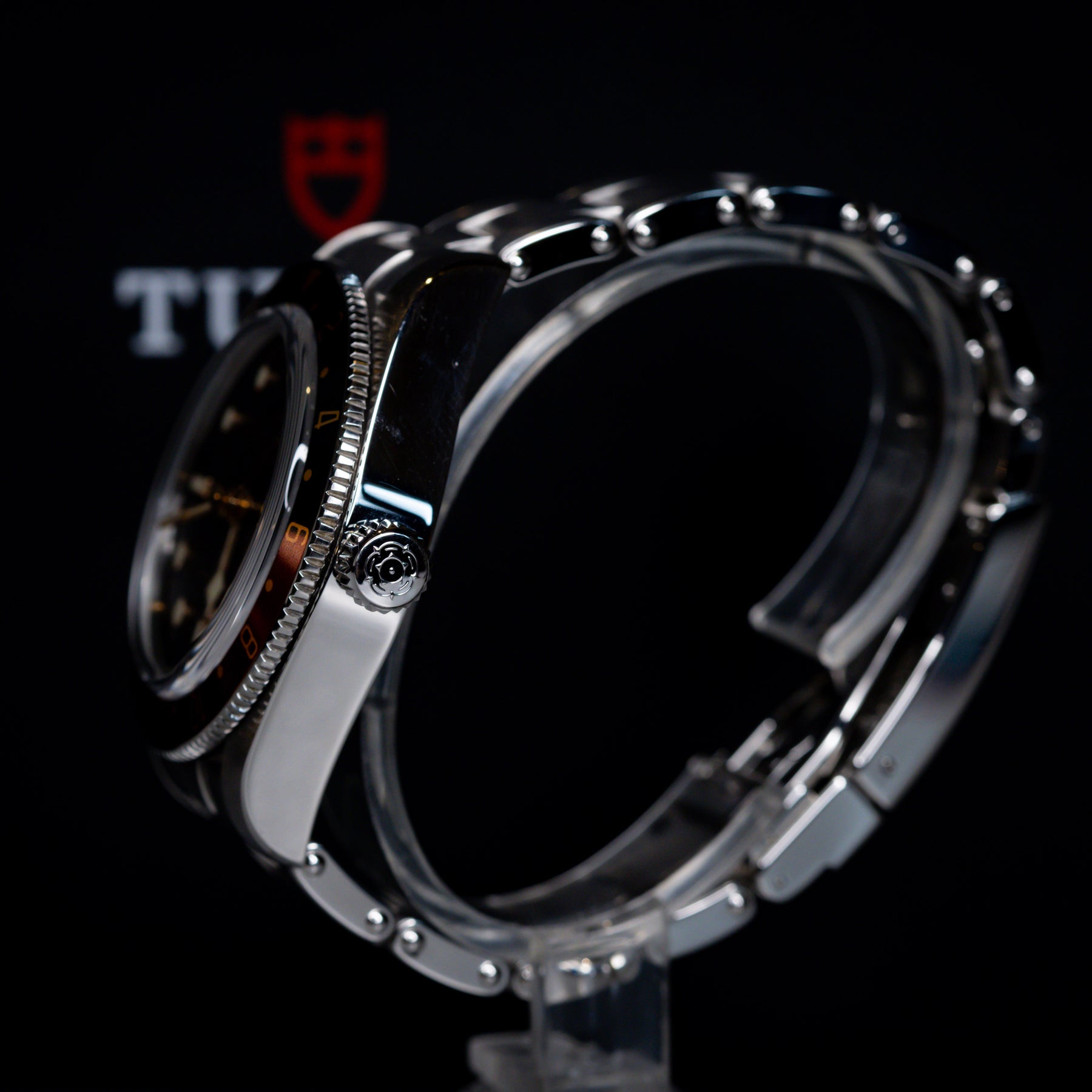 Tudor Black Bay 58 GMT Coke watch showcased from the side, highlighting the black dial and steel bracelet.
