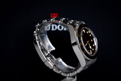 Tudor Black Bay 58 GMT Coke watch side view showcasing stainless steel case and black dial.