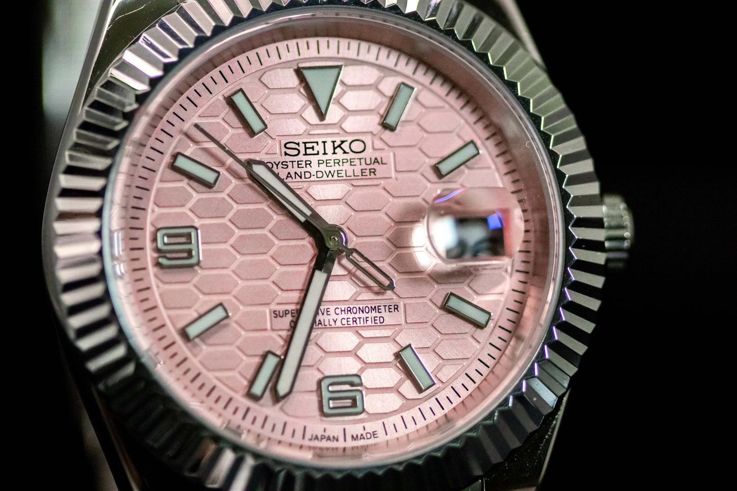 Seiko Pink Land Dweller watch with salmon dial and stainless steel case, showcasing elegant and robust design.