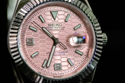 Seiko Pink Land Dweller watch with salmon dial and stainless steel case, showcasing elegant and robust design.