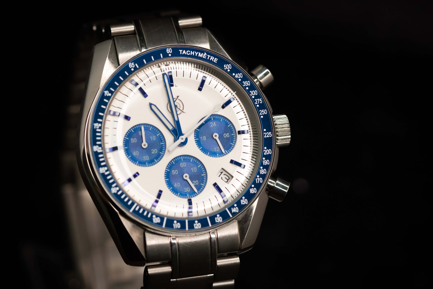 KWC Snoopy Chronograph watch featuring a white dial, blue subdials, and stainless steel bracelet, inspired by Speedmaster design.