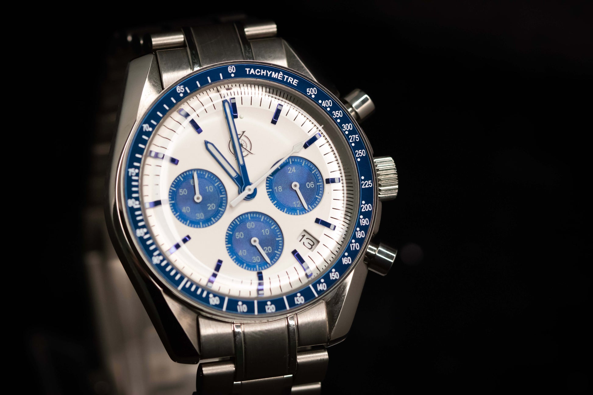 KWC Snoopy Chronograph watch featuring a white dial, blue subdials, and stainless steel bracelet, inspired by Speedmaster design.