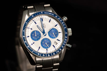KWC Snoopy Chronograph watch featuring a white dial, blue subdials, and stainless steel bracelet, inspired by Speedmaster design.