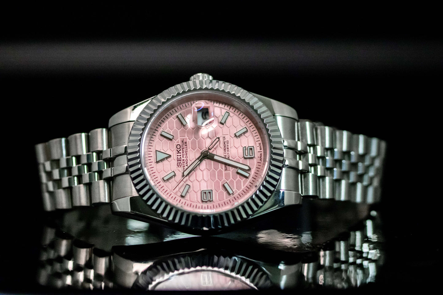 Seiko Mod Pink Land Dweller watch with pink dial, stainless steel case, and automatic movement, showcasing sophistication and durability.