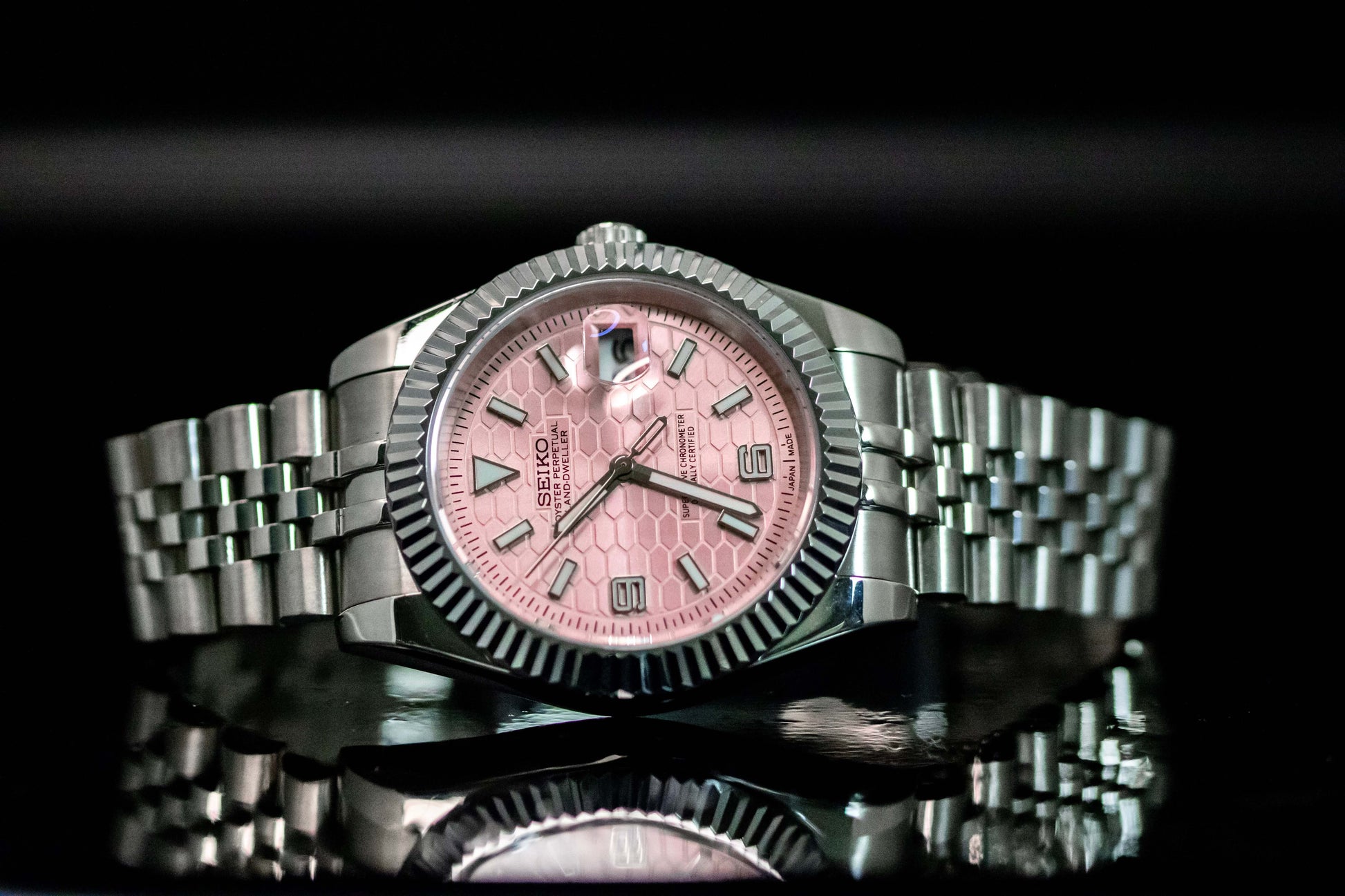 Seiko Mod Pink Land Dweller watch with pink dial, stainless steel case, and automatic movement, showcasing sophistication and durability.