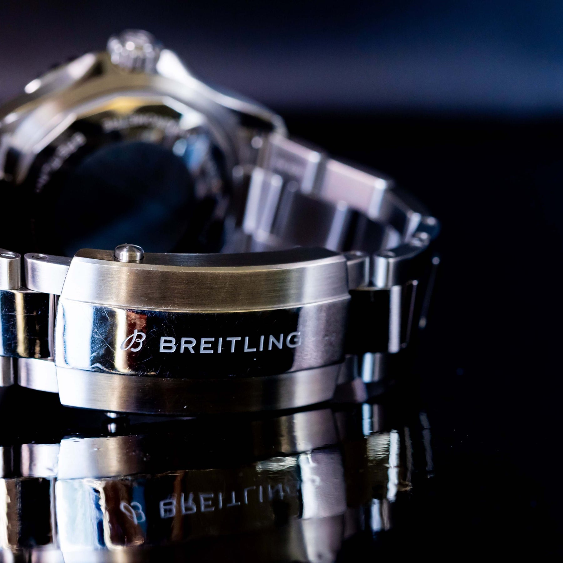 Close-up of Breitling Superocean Automatic 42 watch bracelet showcasing logo and reflective surface.