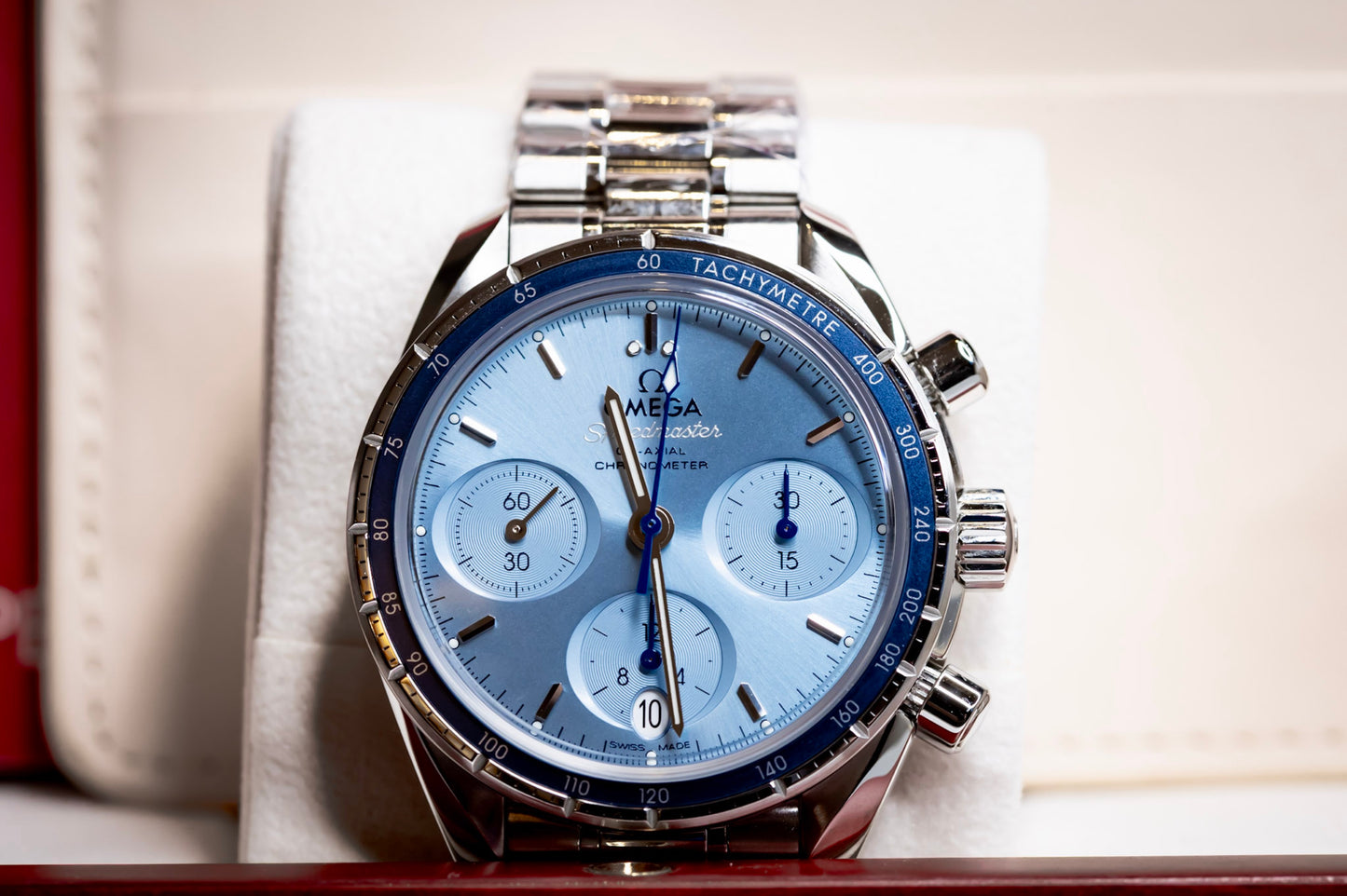 Omega Speedmaster 38mm blue dial chronograph on display with blue dial and stainless steel bracelet.