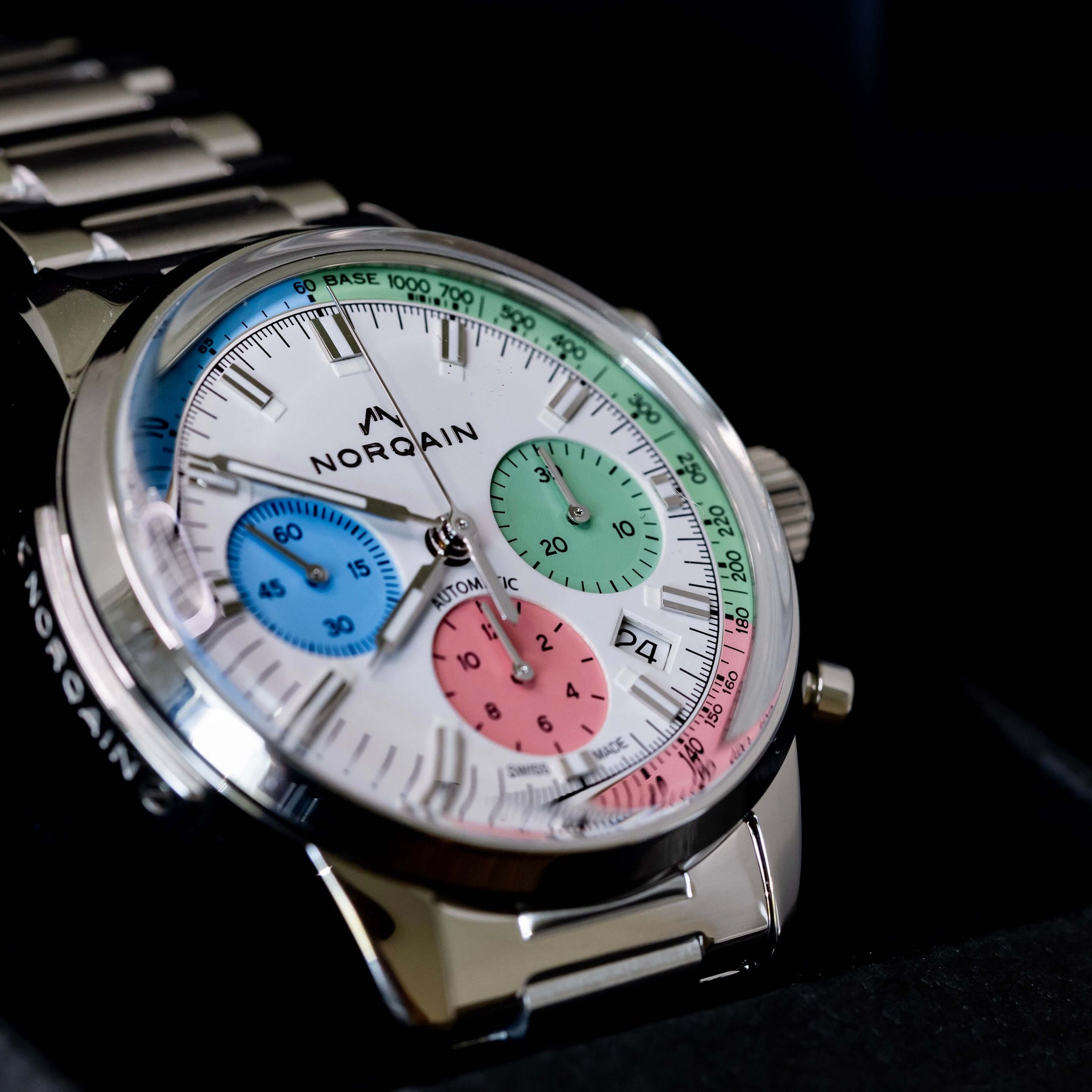 Norqain Freedom 60 Chrono Ice Cream Limited Edition with colorful dials and stainless steel bracelet in a display case.