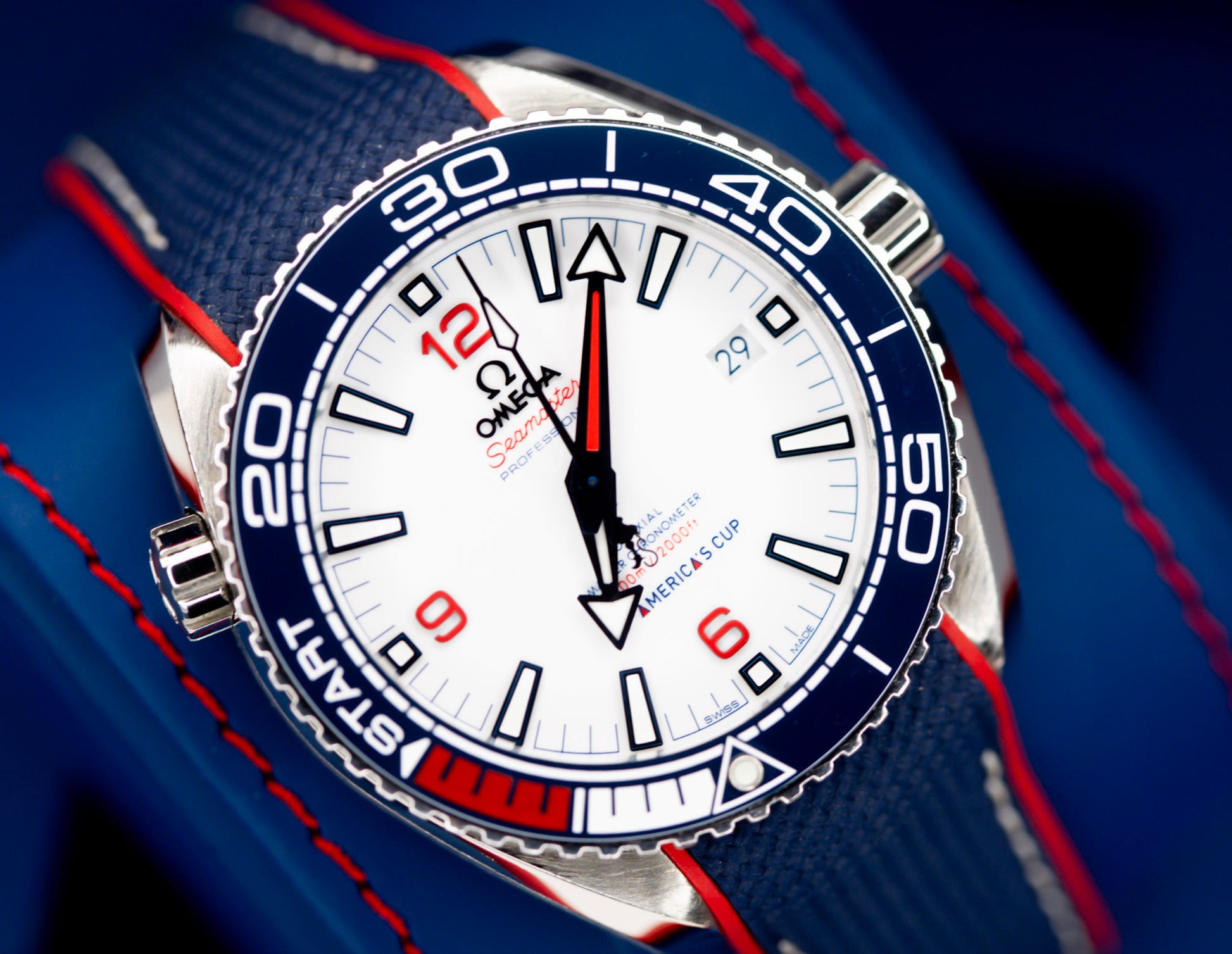 Omega Seamaster America's Cup watch close-up with white dial and blue accents.