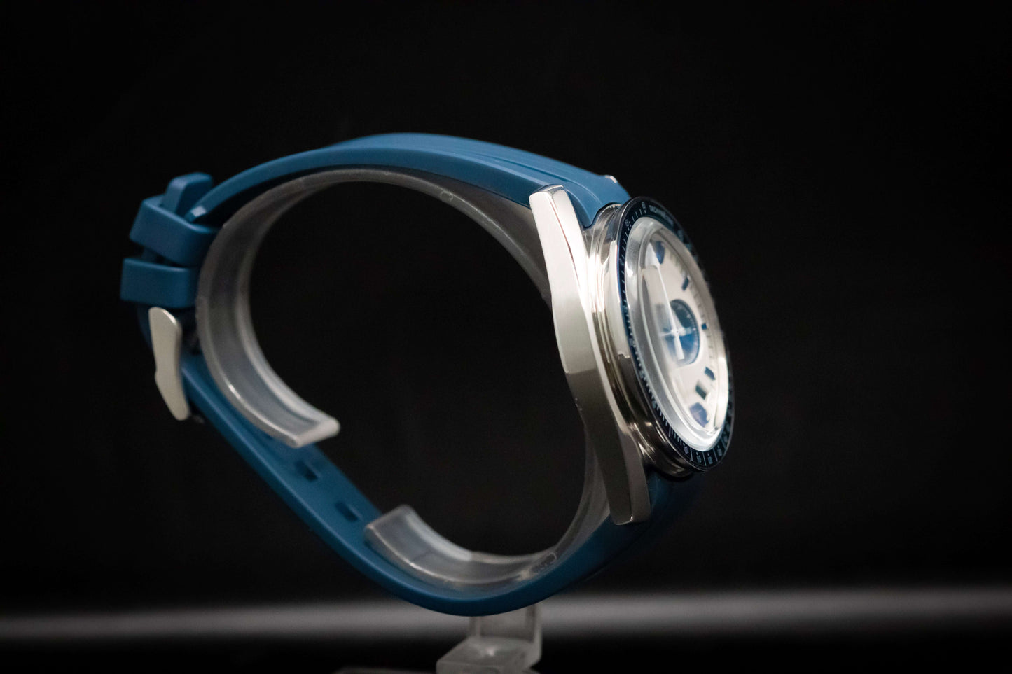 KWC Snoopy Chronograph watch side view with blue rubber strap and stainless steel case, showcasing a white dial.