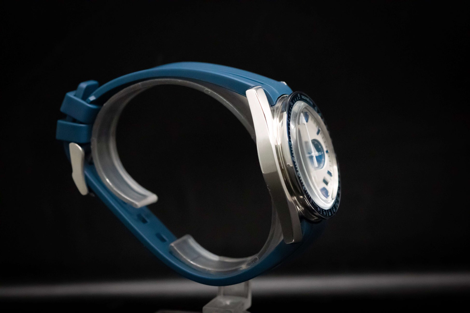 KWC Snoopy Chronograph watch side view with blue rubber strap and stainless steel case, showcasing a white dial.