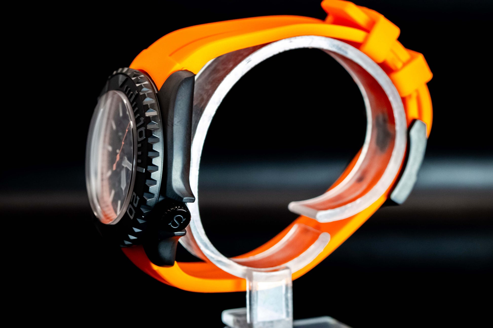 Side view of the Seikomod Orange Skeleton SKX watch showcasing its vibrant orange strap and striking stainless steel case.