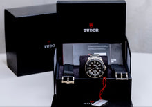 Tudor Pelagos dive watch displayed in luxury packaging with extra straps and certification details.