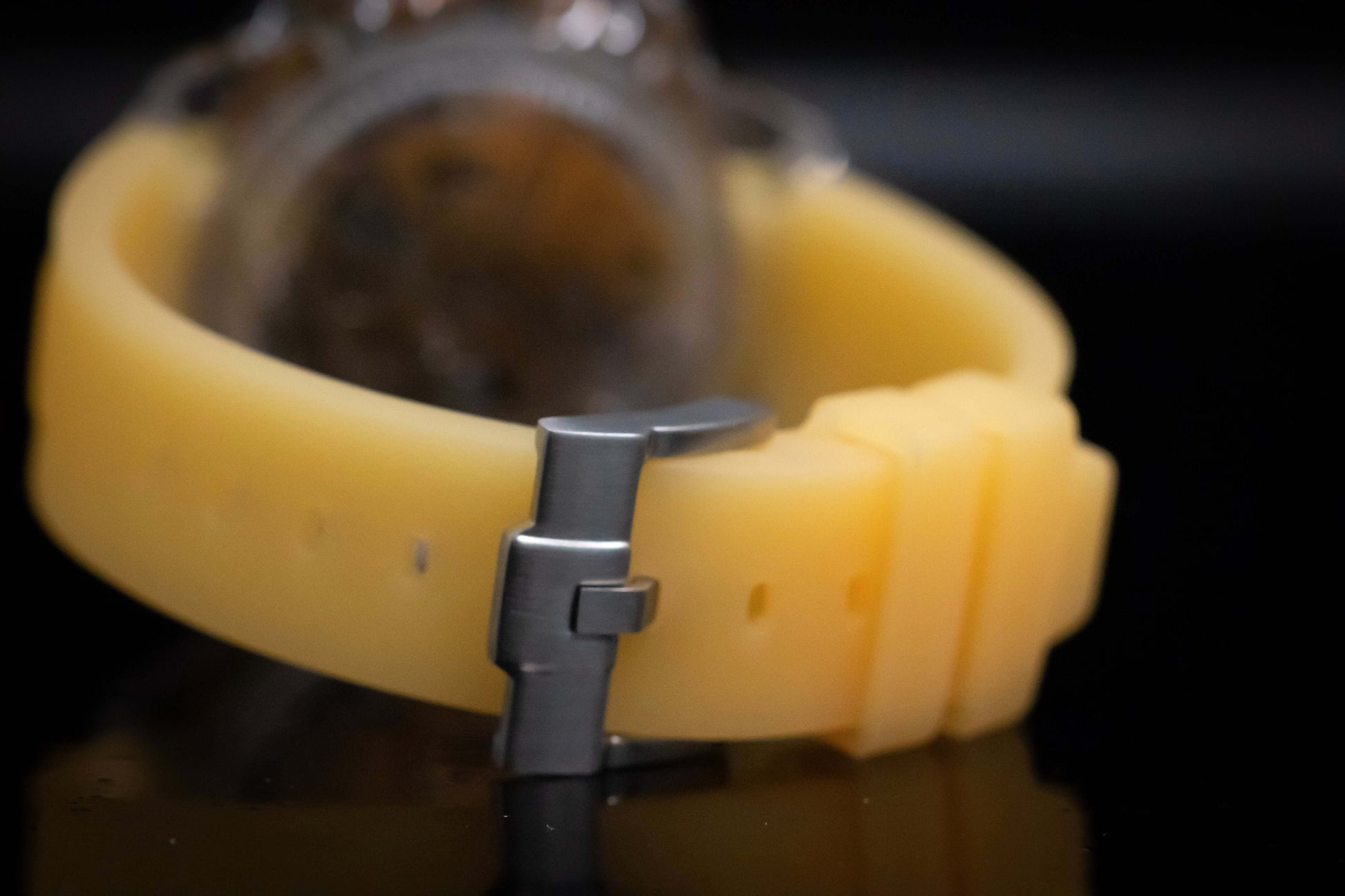 Close-up of the KWC Orange Ceramic Chronograph watch strap featuring a durable yellow silicone band.