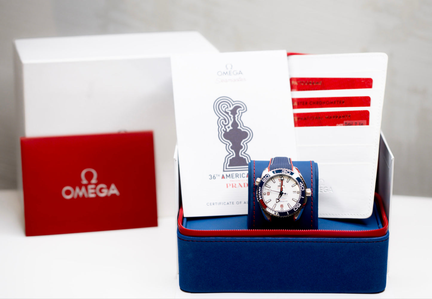 Omega Seamaster America's Cup watch displayed in original box with papers and accessories.