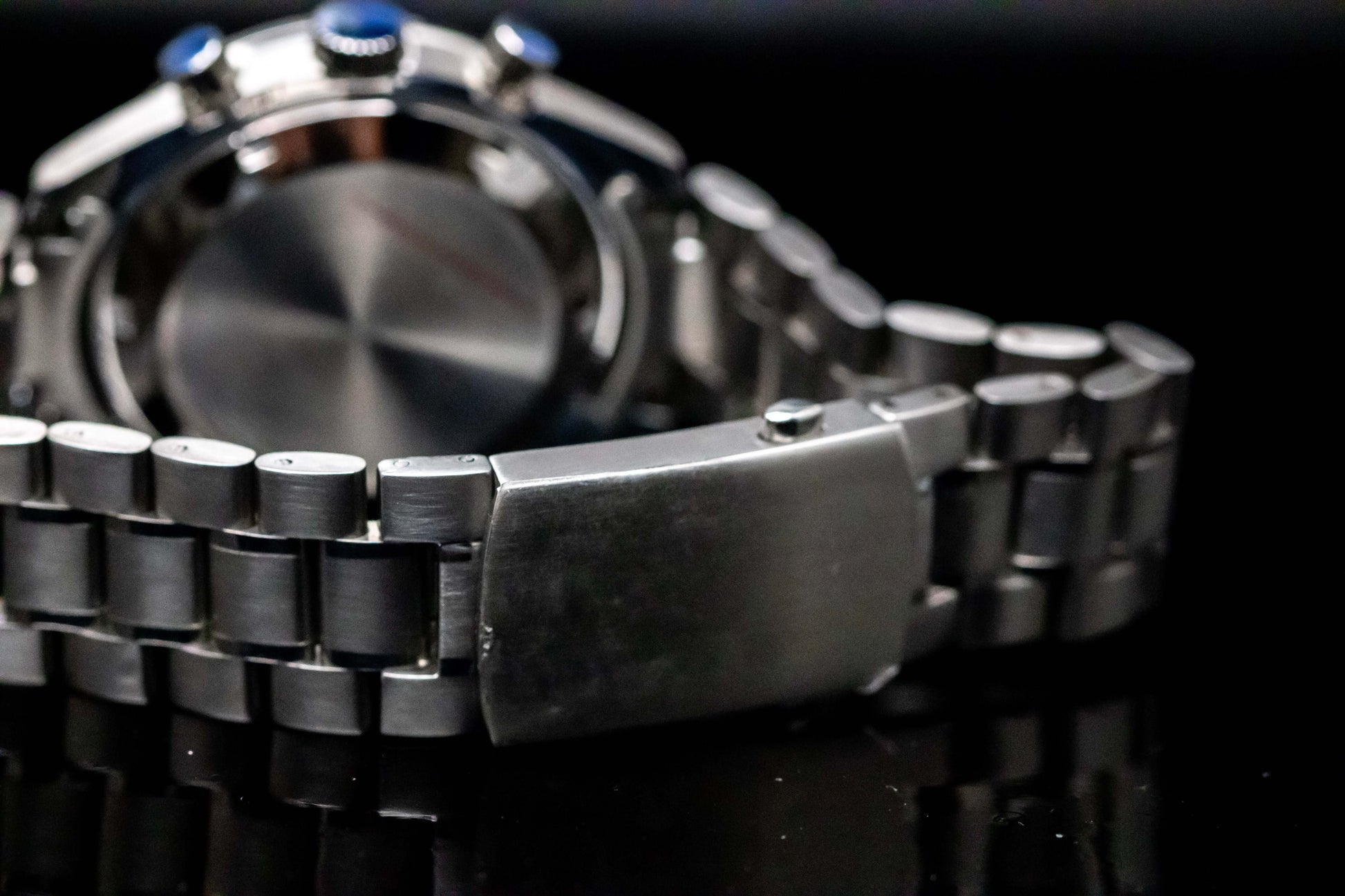 Detail view of the stainless steel bracelet and case back of the Seikomod Speedmaster Snoopy watch.