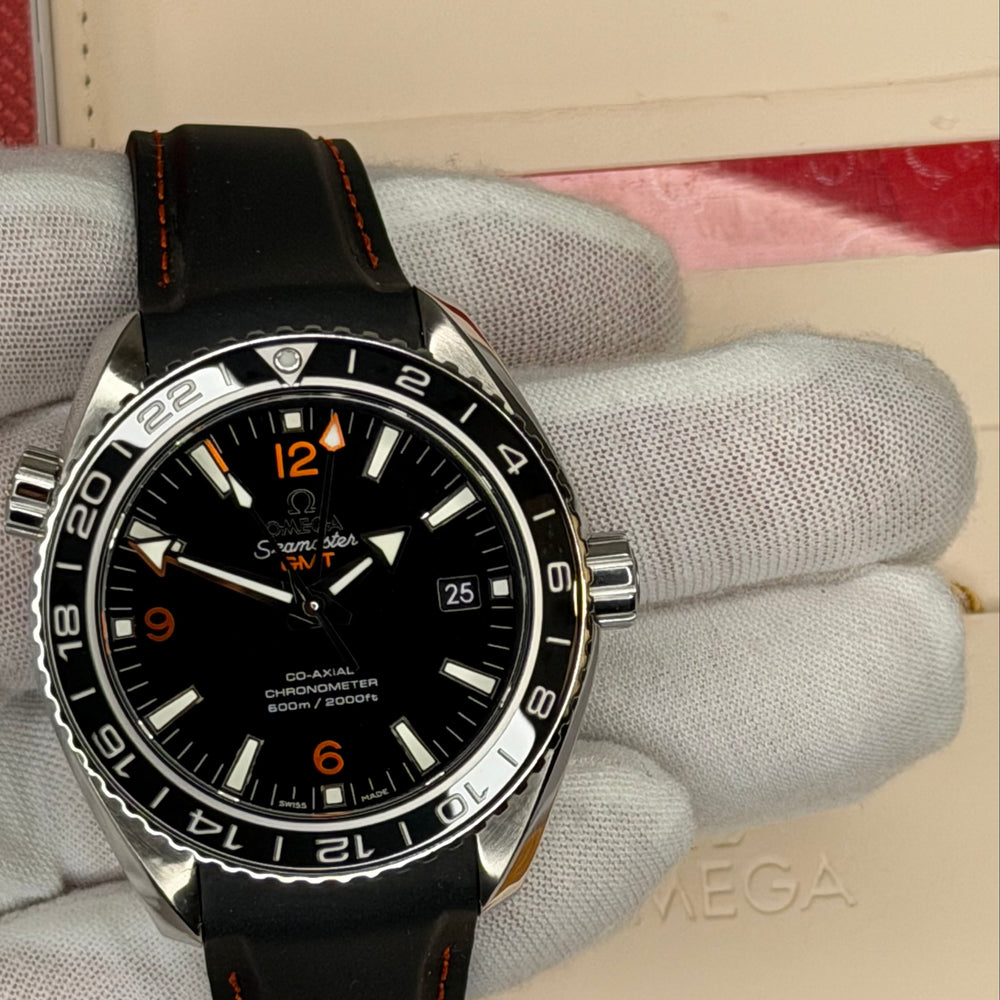 2024 Omega Seamaster Planet Ocean GMT watch displayed with original warranty box.
