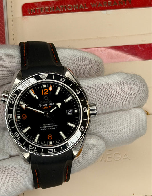2024 Omega Seamaster Planet Ocean GMT watch displayed with original warranty box.