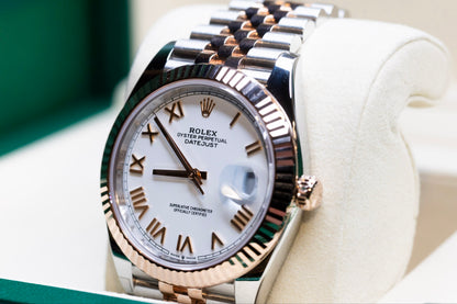 2025 Rolex Datejust 41 rose gold watch displayed in a luxurious watch box with a white dial and Roman numerals.