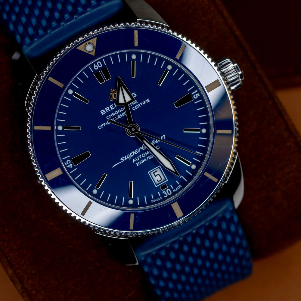 Breitling Superocean Heritage B20 46 watch featuring a blue dial and mesh strap, displayed on a leather surface.