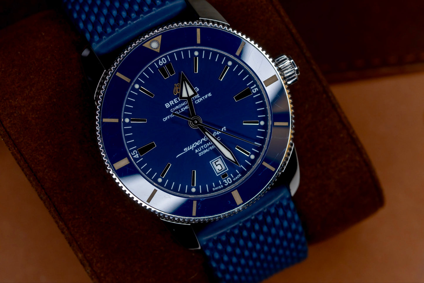 Breitling Superocean Heritage B20 46 watch featuring a blue dial and mesh strap, displayed on a leather surface.