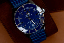 Breitling Superocean Heritage B20 46 watch featuring a blue dial and mesh strap, displayed on a leather surface.