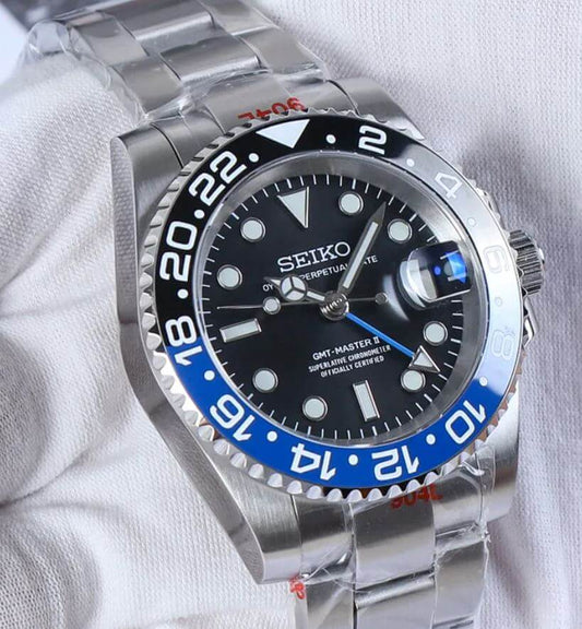 Seiko GMT-Master Batman watch with black dial, blue bezel, and stainless steel bracelet, showcasing precision craftsmanship.