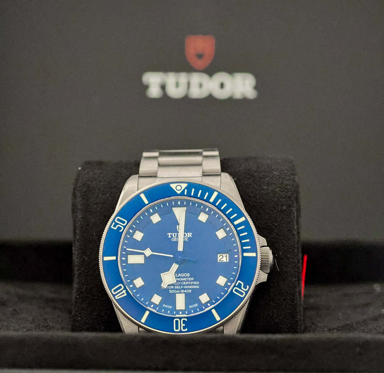 TUDOR Pelagos Titanium Diver watch - 42mm Blue Dial Diver – Full Set displayed on a plush black watch holder.