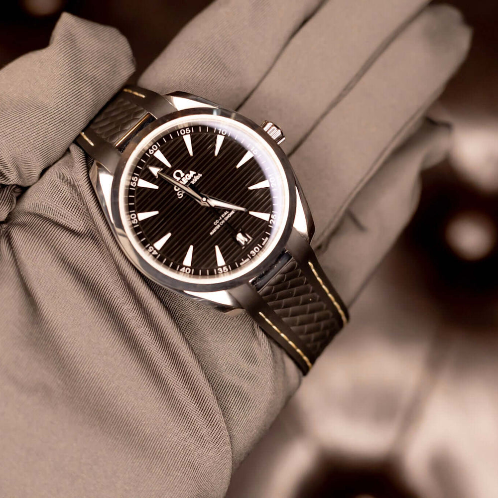 2022 Omega Seamaster Aqua Terra watch displayed on a hand with a black teak-pattern dial and stainless steel case.
