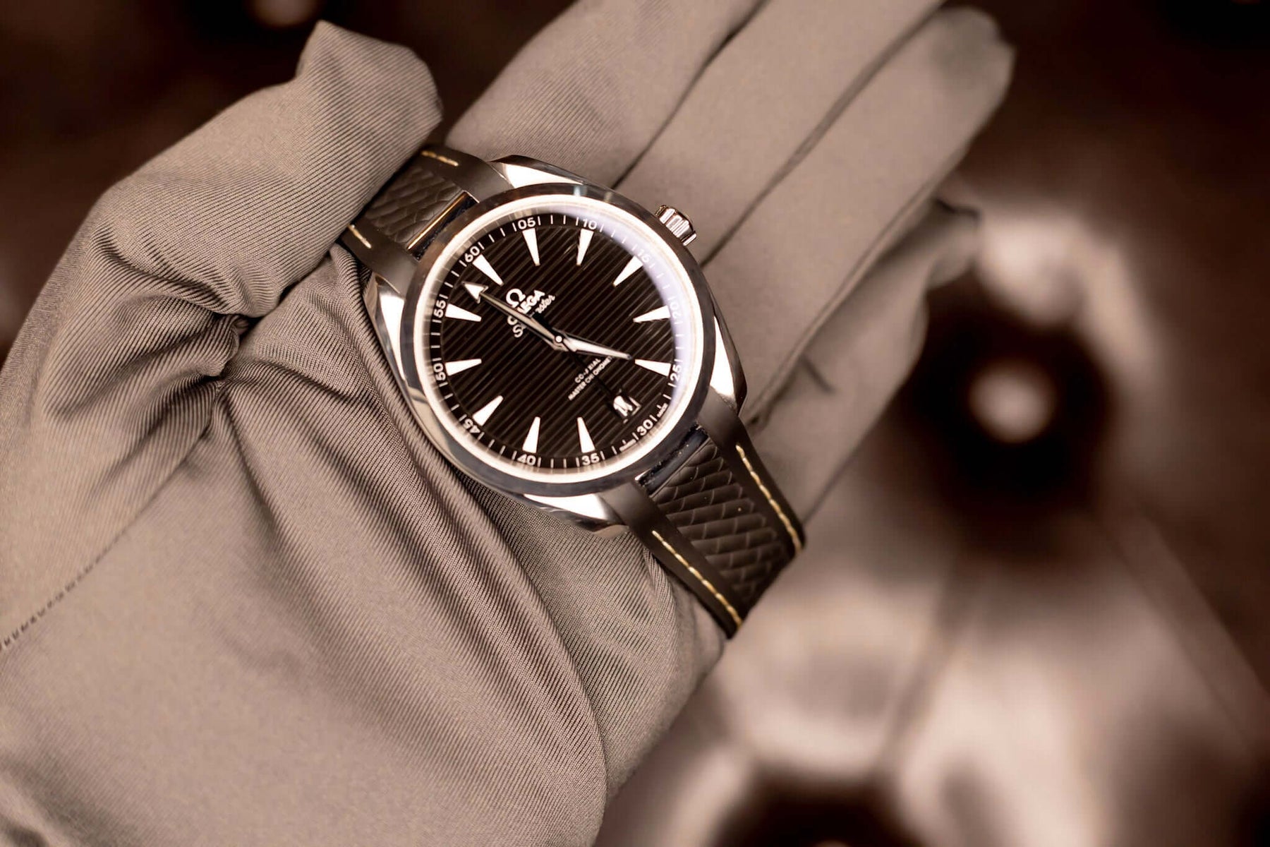 2022 Omega Seamaster Aqua Terra watch displayed on a hand with a black teak-pattern dial and stainless steel case.