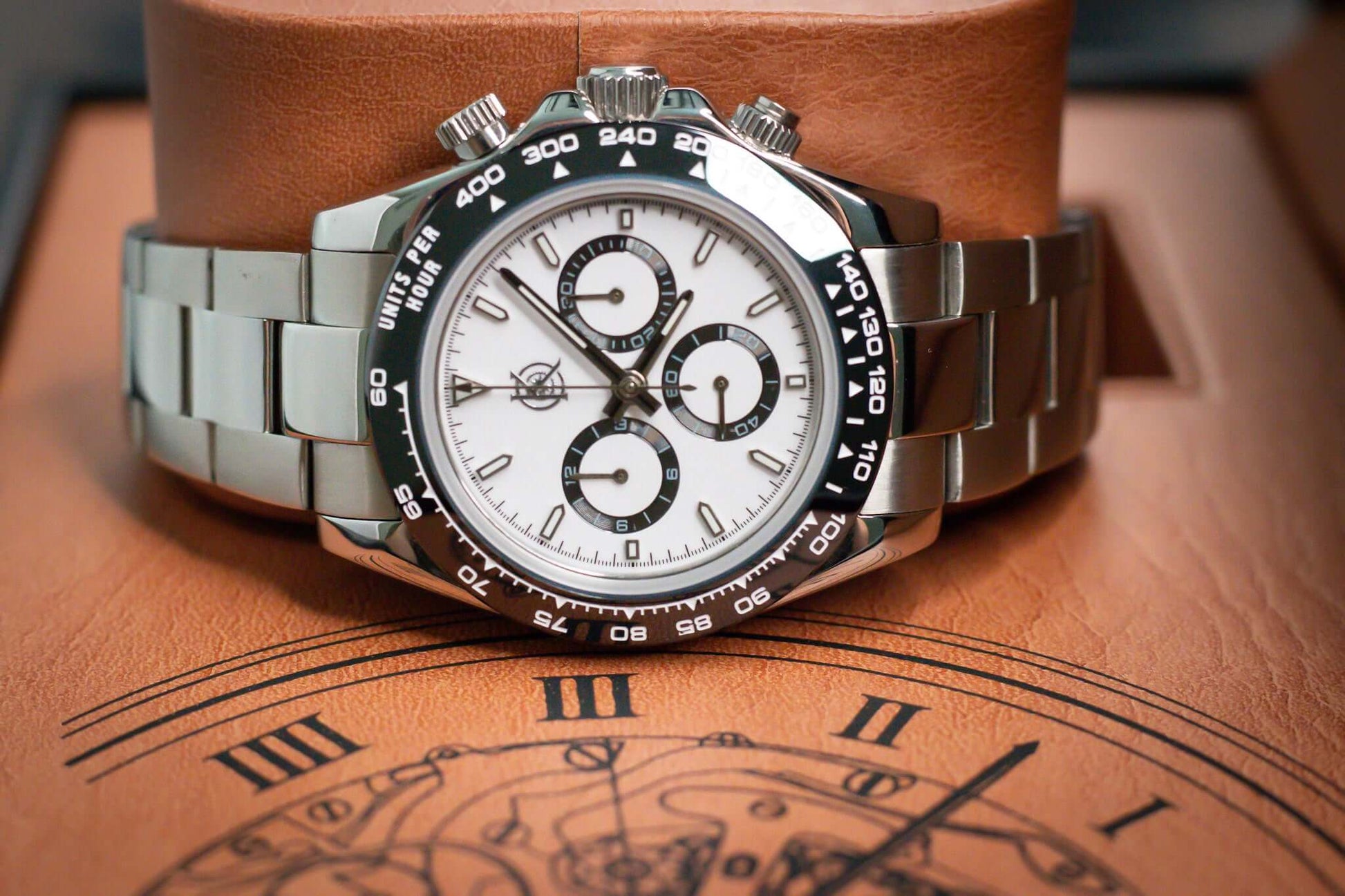 Kingdom 7750 Automatic Chronograph watch with white dial and stainless steel bracelet on a leather display.