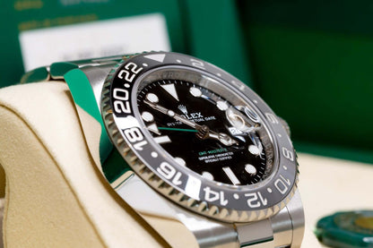 2025 Rolex GMT-Master II Bruce Wayne showcasing black dial and ceramic bezel, displayed elegantly on a plush cushion.
