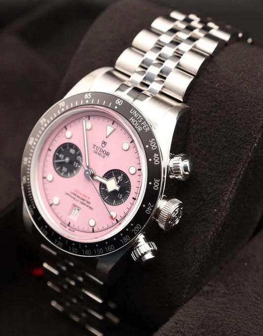 Tudor Black Bay Chrono Pink 79360N with pink dial and stainless steel bracelet on black display.