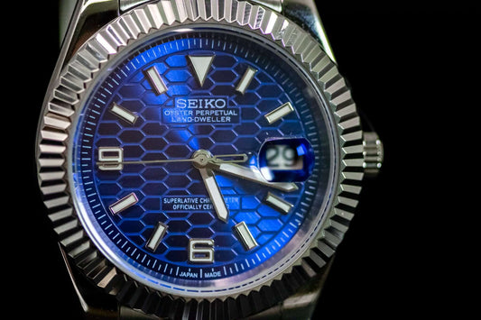 Close-up of SeikoMod Land Dweller watch with blue hexagonal dial and stainless steel case.