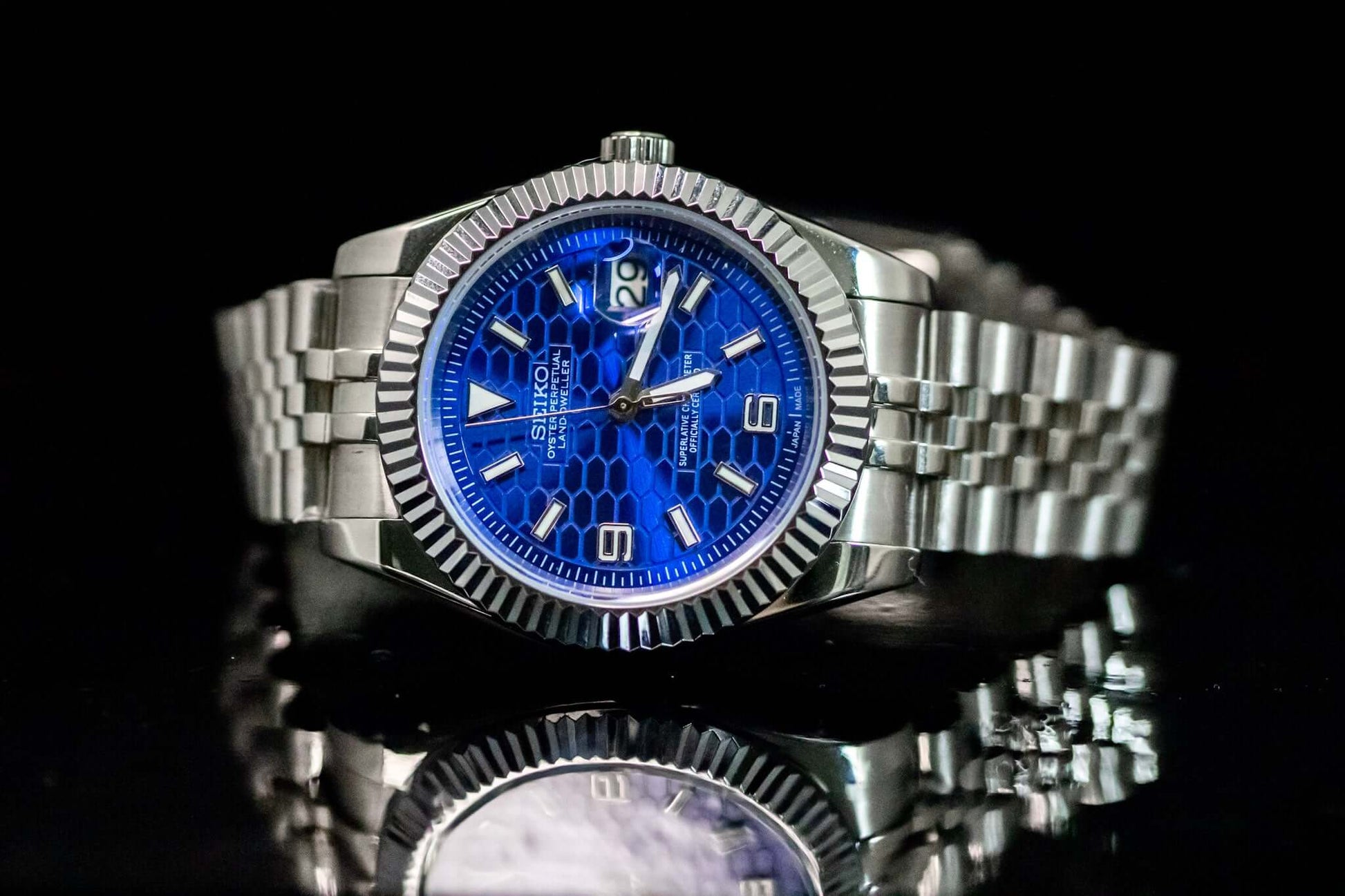 Blue SeikoMod Land Dweller watch with a bold honeycomb dial and stainless steel bracelet, reflecting elegance and durability.