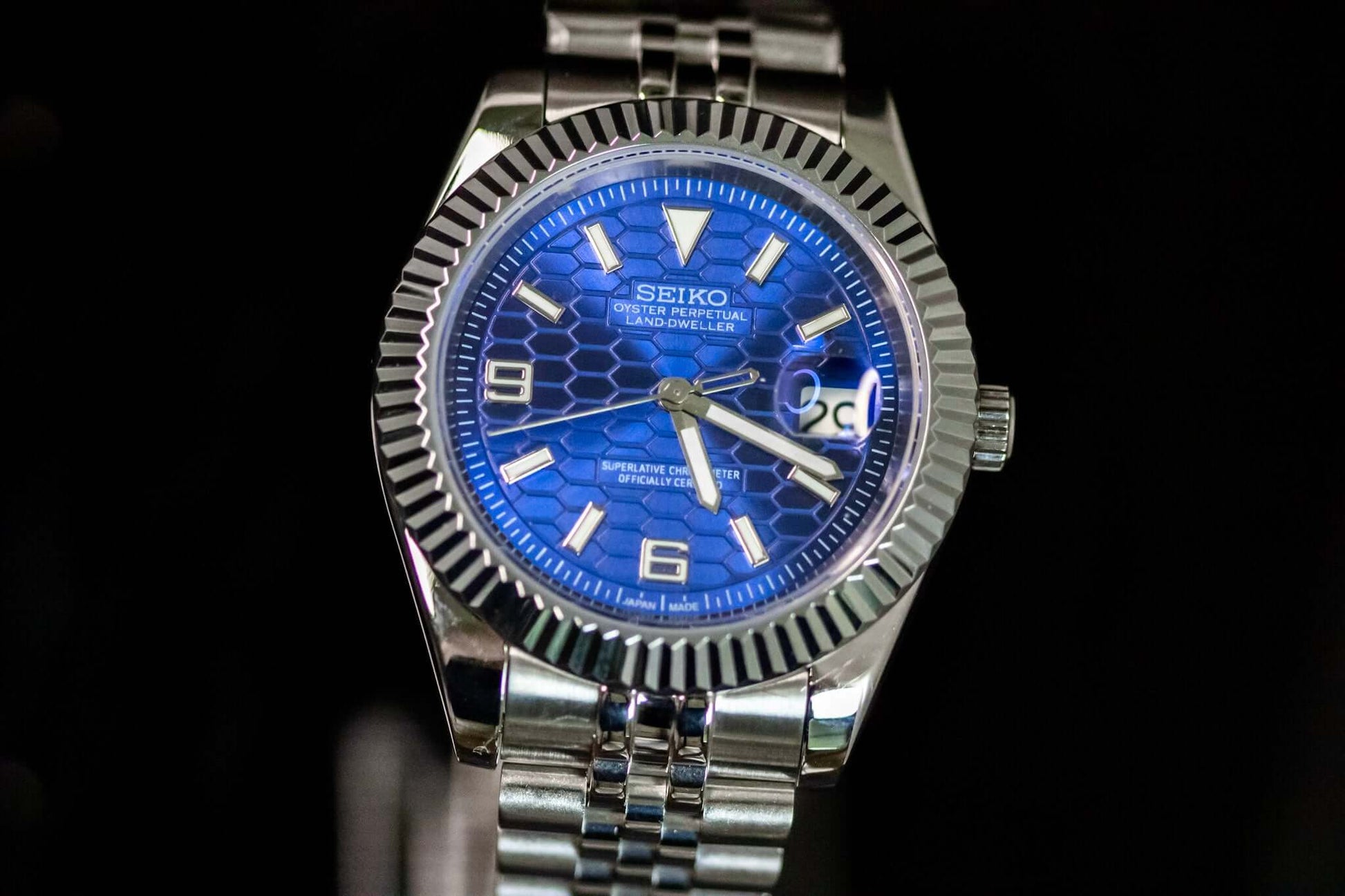 Blue SeikoMod Land Dweller watch with bold dial and stainless steel bracelet.