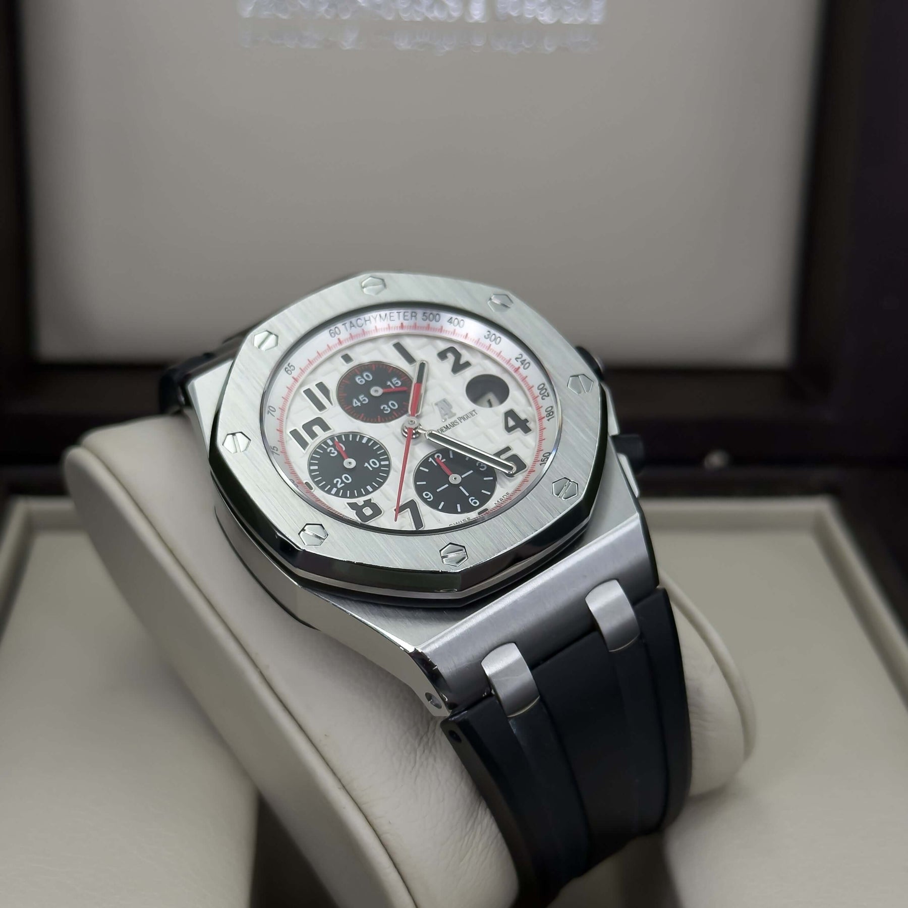 Audemars Piguet Royal Oak Offshore men's watch on display, featuring a white dial with red accents and a sleek black rubber strap.
