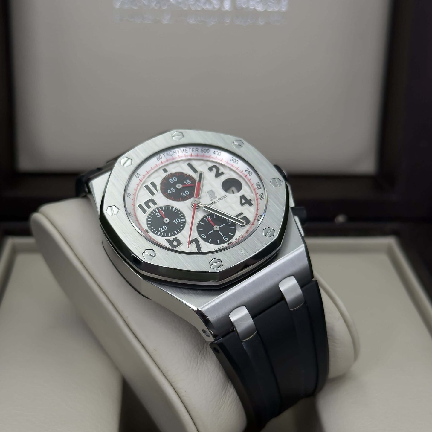 Audemars Piguet Royal Oak Offshore men's watch on display, featuring a white dial with red accents and a sleek black rubber strap.