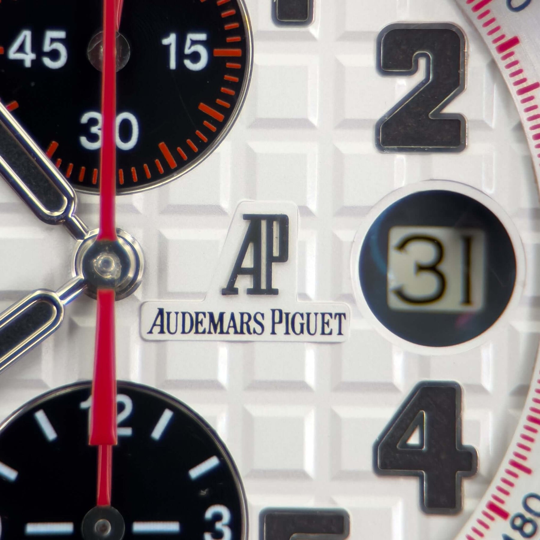 Close-up of Audemars Piguet Royal Oak Offshore men's watch dial with white Tapisserie pattern and chronograph details.