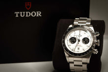 Tudor Black Bay Chronograph Panda displayed on a plush stand next to its distinctive black box.