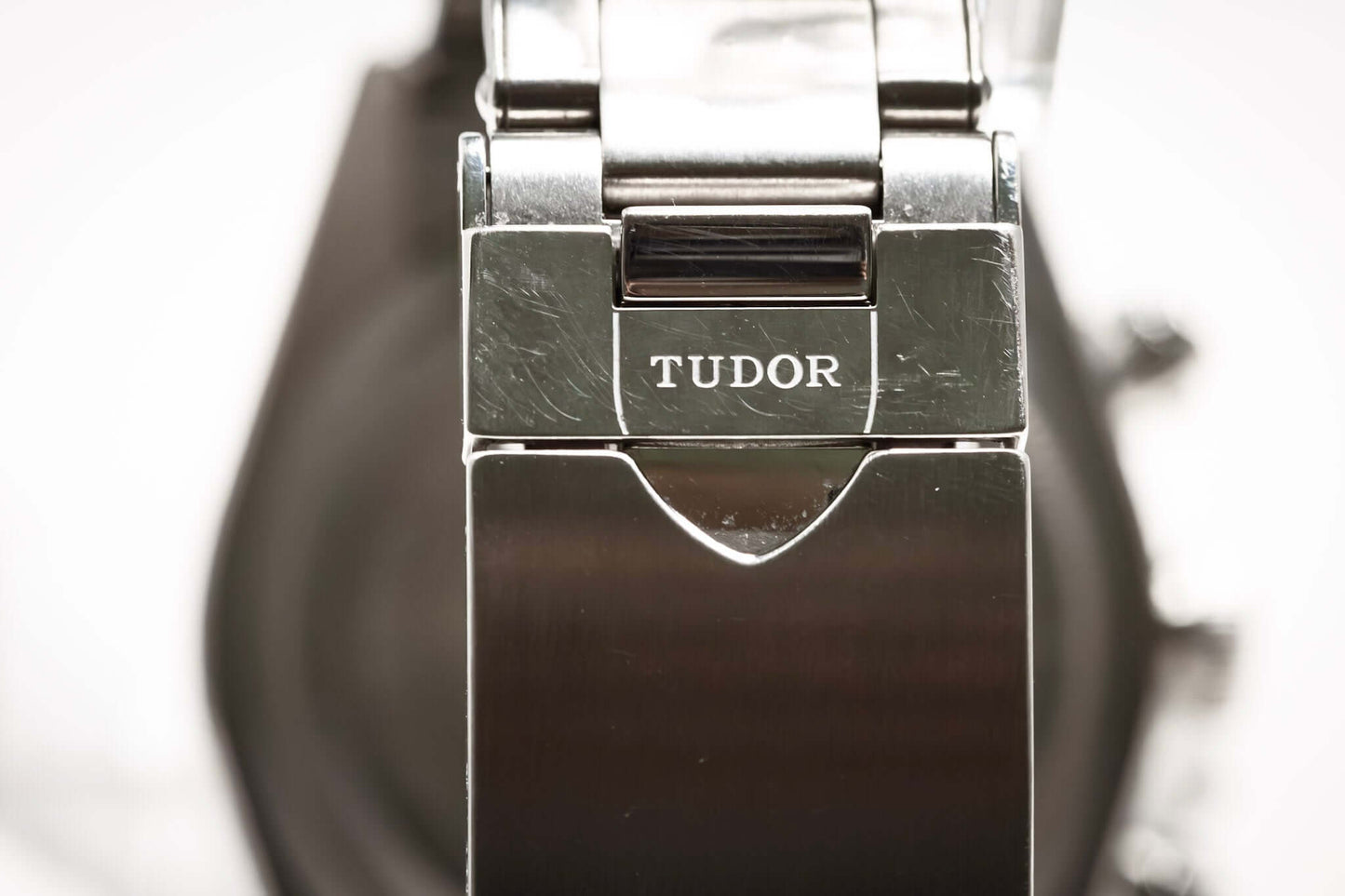 Close-up of the Tudor logo on the clasp of the Tudor Black Bay Chronograph Panda watch.