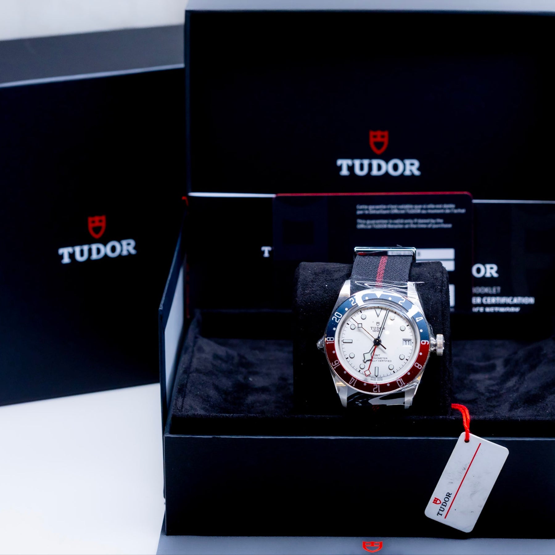 Tudor Black Bay GMT Pepsi watch displayed in its original packaging with certification papers.