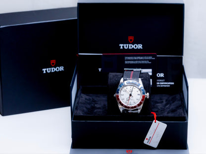 Tudor Black Bay GMT Pepsi watch displayed in its original packaging with certification papers.