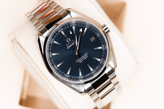 Close-up of Omega Seamaster Aqua Terra watch with blue Teak Concept dial and stainless steel bracelet.