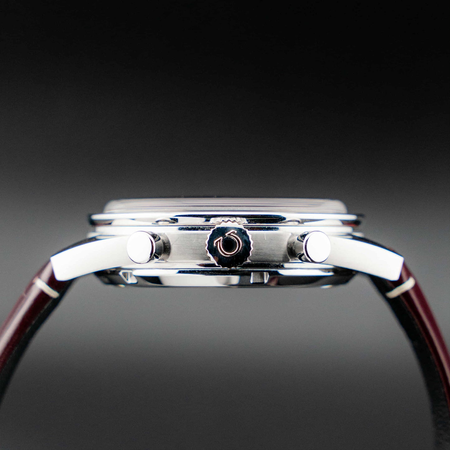 Omega Speedmaster '57 Burgundy full set side view showcasing the case and chronograph buttons.